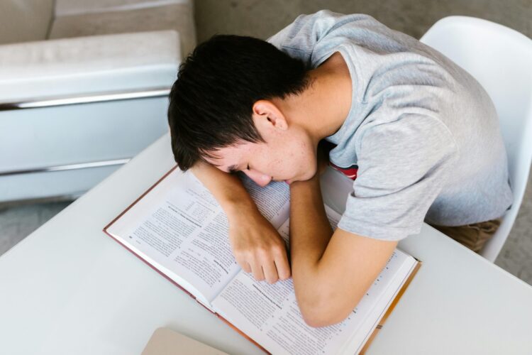 Student sleeping on a open book