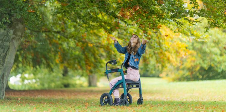 Women sitting on walking frame under tree