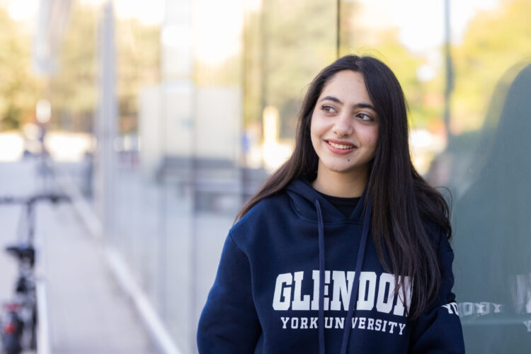 Student leaning on glass wall