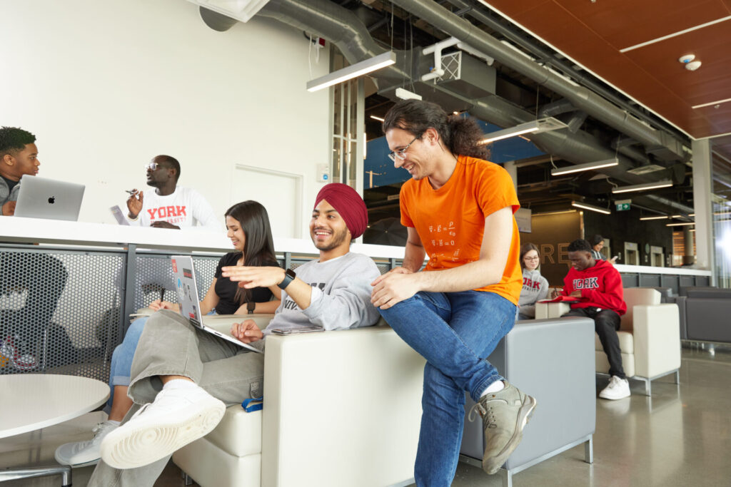 Students talking while sitting down on sofa chair