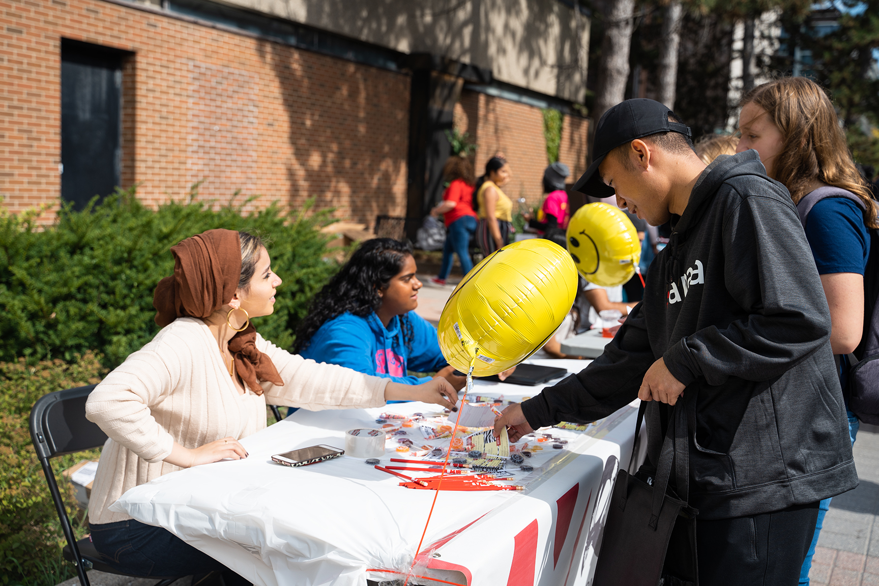 Student standing in front of a booth at a tabling event