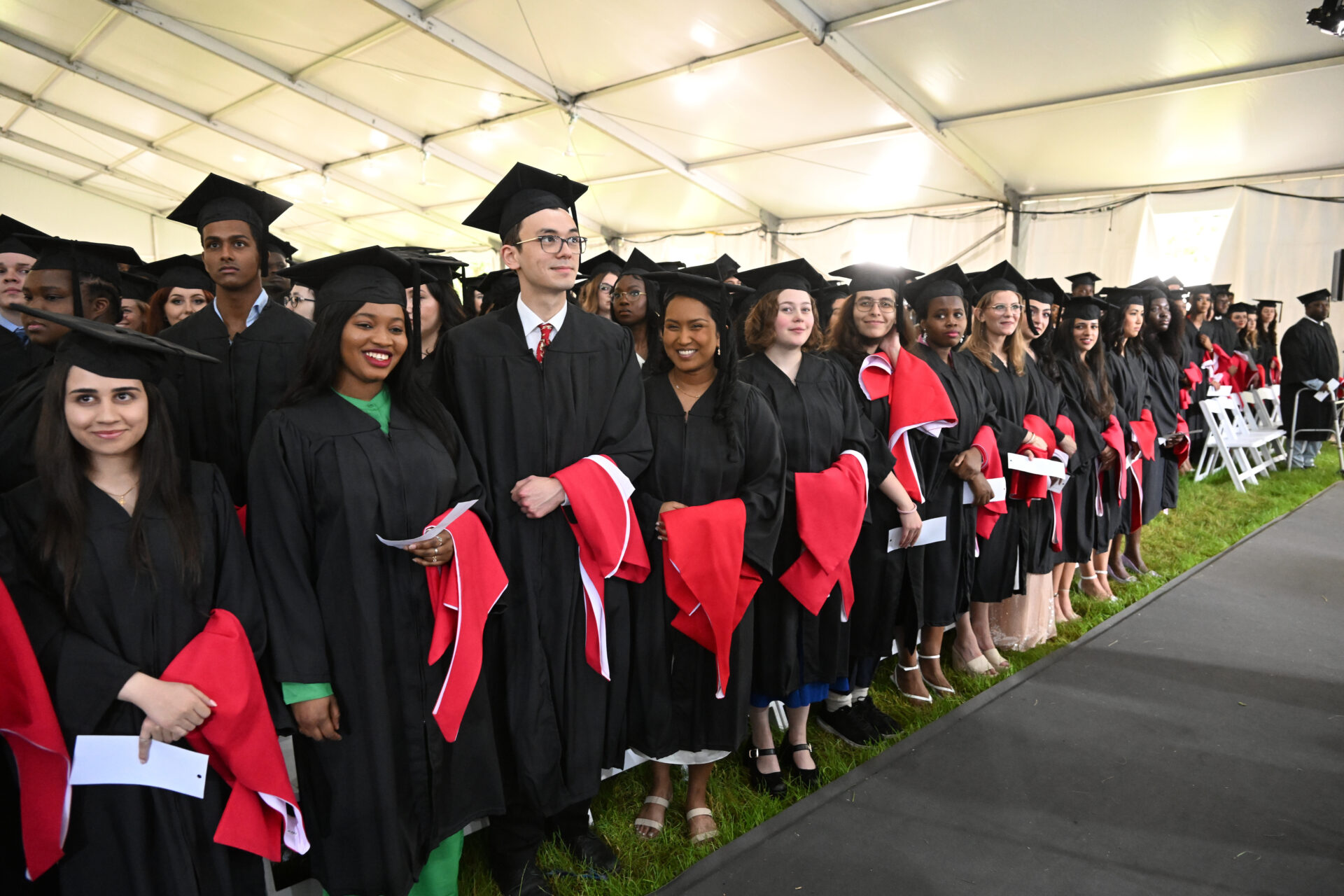 Students in academic gowns standing at a convocation ceremony