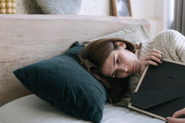 https://www.pexels.com/photo/a-woman-hugging-a-picture-frame-while-lying-down-on-a-bed-6788760/